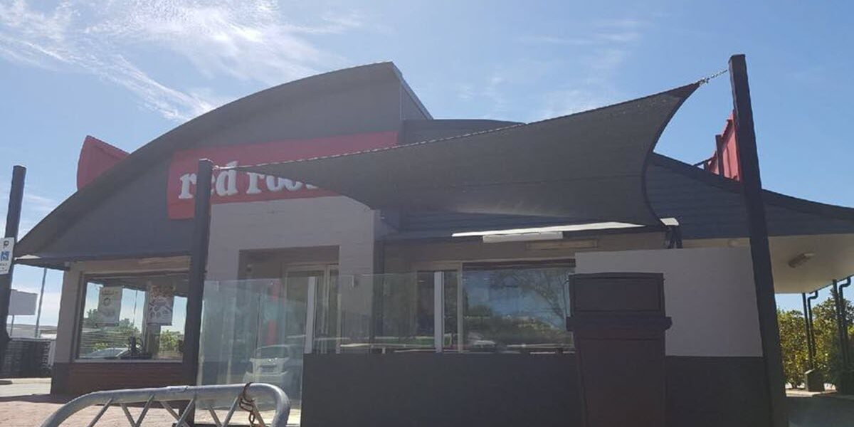 Shade sail at a red rooster restaurant.